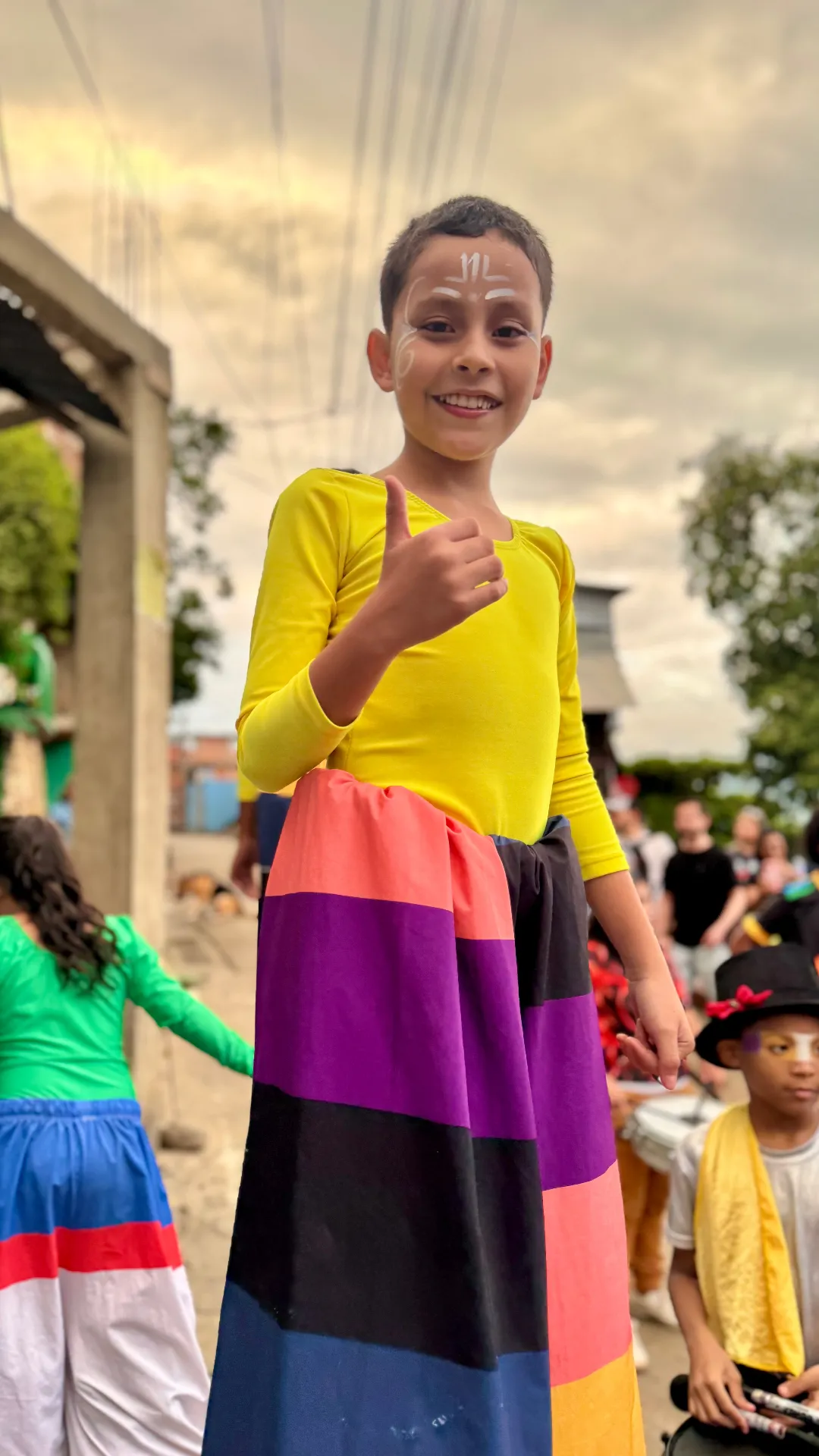 Niño con traje colorido en un desfile comunitario de Siloé